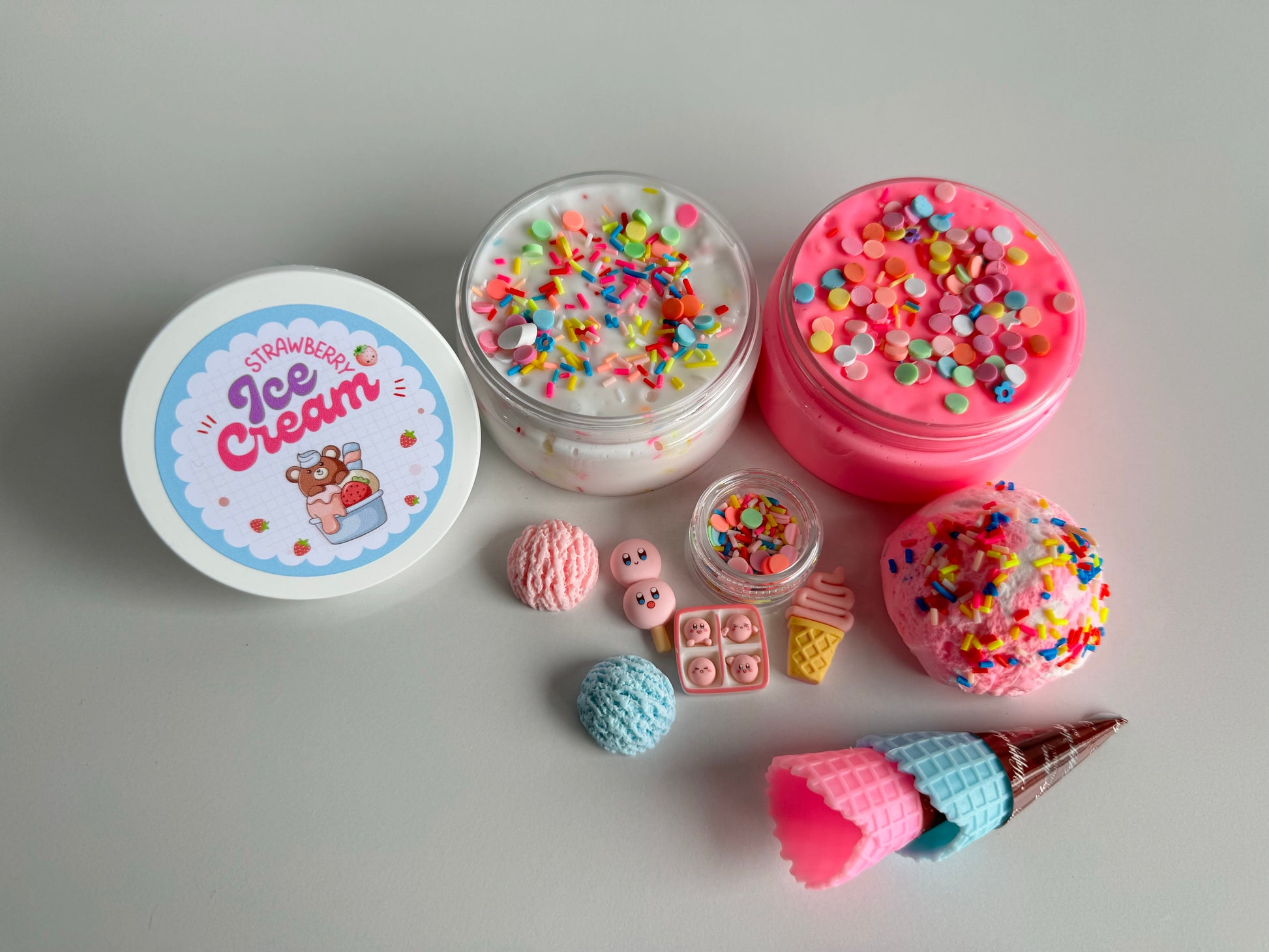 Our delicious strawberry ice cream slime kit. White slime filled with sprinkles and a pink slime. Ice cream scoop clay piece with accessories 